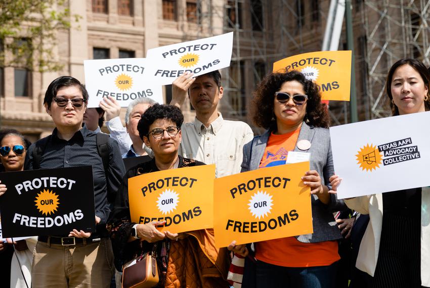 Members of the Texas Asian American Pacific Islander (AAPI) Collective hold signs during a press conference at the state Capitol on March 9, 2023.