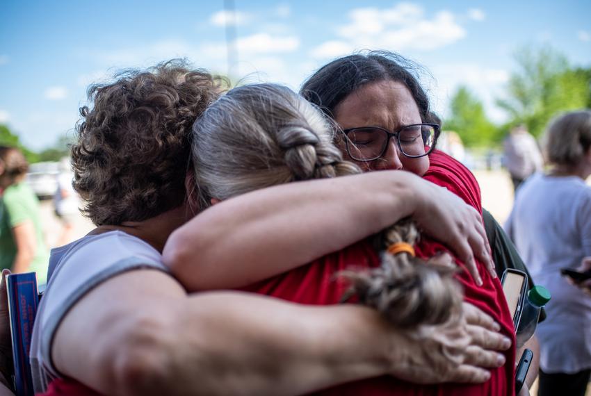 Amanda Starkes and her mother Brenda embrace Suzette Baker after the announcement that the Llano Public library will remain open outside the Llano County Sheriffs office on Thursday, April 13, 2023. Baker and Starke were both terminated from the library branch in Kingsland. The county ruled that the library will remain open after a vote on whether or not to close it due to disagreements over book banning. (Sergio Flores for the Texas Tribune)