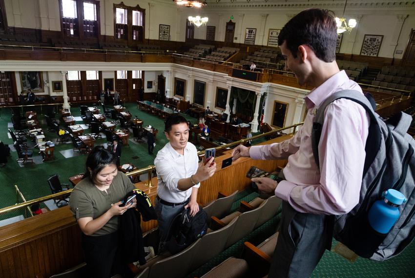 Nicole Ma and Steven Wu of Woori Juntos exchange virtual business cards and phone numbers with another organizer as they prepare to leave the Senate gallery in the state Capitol in Austin on May 22, 2023. The Woori Juntos organizers have shifted focus for the remaining time in the Legislative session. and are hoping to begin building alliances with other organizations for next session.