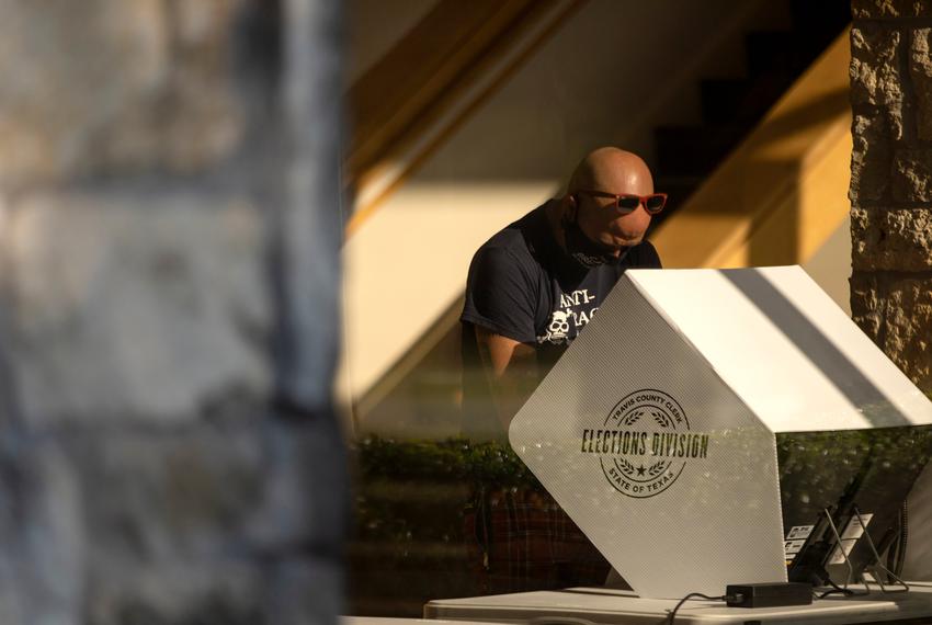 A voter casts their ballot at a polling site at the Austin Oaks Church on Oct. 14, 2020.