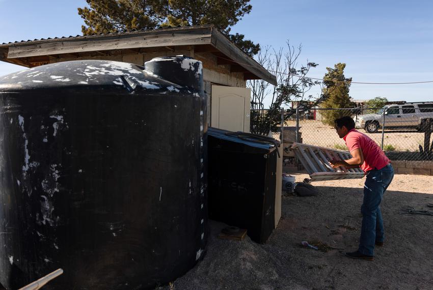 Maria Martínez’s son Jose Martínez removes a makeshift cover for plumbing near a water tank on April 21, 2023. Without the insulation during the winter, the pipes are prone to burst in the colder temperatures.
