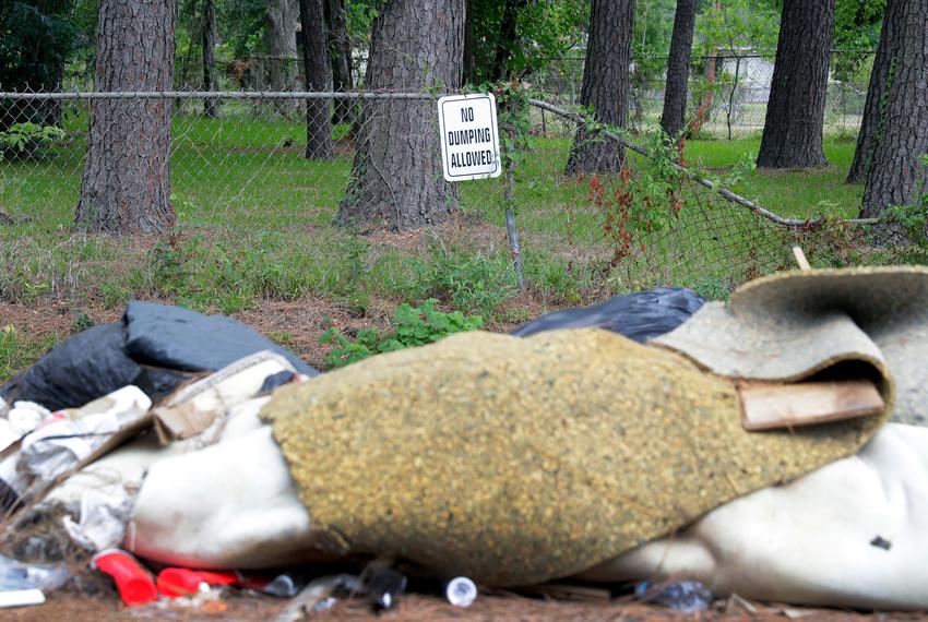 Trash piles up at a spot south of the Houston Gardens Park where it is regularly dumped on the road right next to a “No Dumping Allowed” sign, on Friday, July 22, 2022 in Houston.
