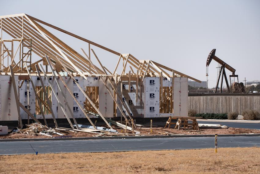 A pumpjack operates nearby a house under construction in a new housing development on March 14, 2022 north of Midland.