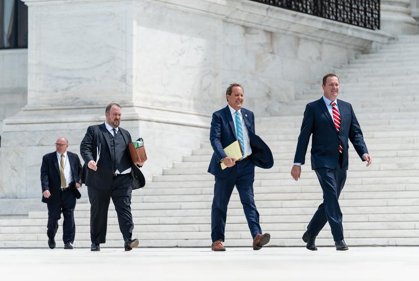 Texas Attorney General Ken Paxton, center right, walks with Texas Solicitor General Judd Stone II, center left, and Missouri Attorney General Eric Schmitt, right, to a press conference at the U.S. Supreme Court in Washington, D.C. on April 26, 2022. Earlier, the U.S. Supreme Court heard oral arguments for Texas v. Texas, the enforcement of the Trump-era “remain in Mexico” policy that required asylum seekers to stay in Mexico as they waited for hearings in U.S. immigration court. (Eric Lee for The Texas Tribune).