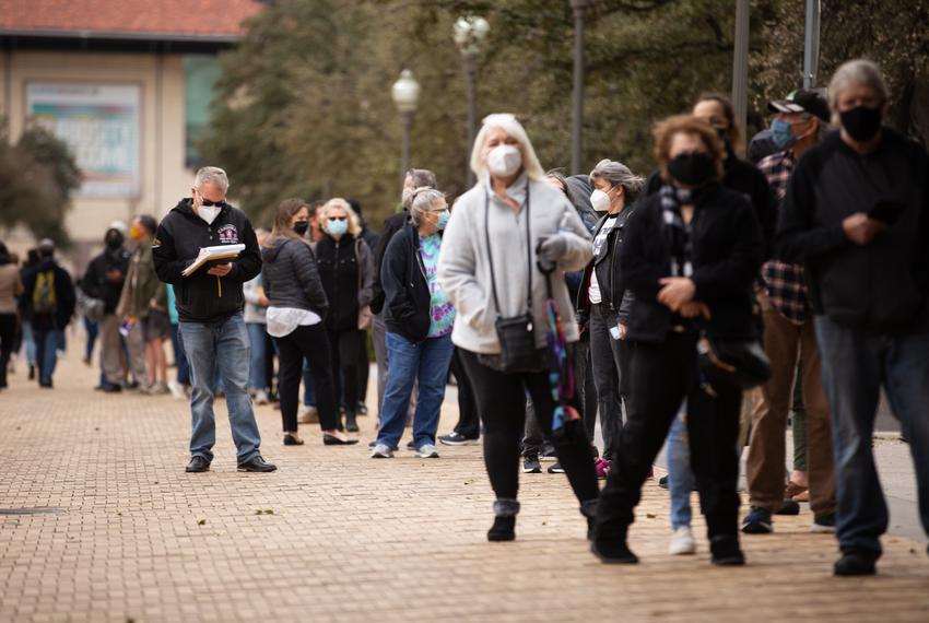 Long lines of people wait to be vaccinated against COVID-19 at the University of Texas campus in Austin on March 1, 2021.  Many individuals waited for roughly two hours before receiving a dose.